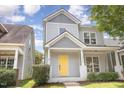Charming two-story home features a bright yellow front door, inviting porch, and neatly landscaped yard at 10744 Cokesbury Ln, Raleigh, NC 27614
