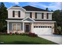 Charming two-story home with a brick facade, a two-car garage, and well-maintained landscaping at 1104 Landen Creek Ln, Zebulon, NC 27597