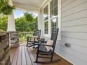 Cozy front porch featuring rocking chairs and a view of the landscaped yard at 1148 Tringham Ct, Apex, NC 27502