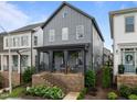 View of the gray two-story home with a welcoming porch and a manicured front yard at 117 Banning Dr, Pittsboro, NC 27312