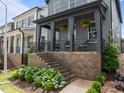 Home's front yard with landscaped garden featuring hydrangea bushes and covered front porch with seating at 117 Banning Dr, Pittsboro, NC 27312