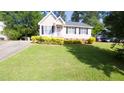 Inviting single Gathering home with green lawn, neat landscaping, and paved driveway at 133 Parkhaven Ln, Garner, NC 27529