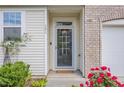 Inviting entryway with a storm door, house number, and lush landscaping with vibrant flowers at 161 Walking Path Pl, Hillsborough, NC 27278