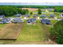 Wide aerial view of home showcasing expansive lot, landscaping, and neighborhood pond in a tranquil setting at 173 Vinson Park Dr, Archer Lodge, NC 27527