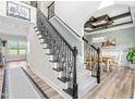 Open foyer with staircase featuring wrought iron spindles and access to dining room at 173 Vinson Park Dr, Archer Lodge, NC 27527