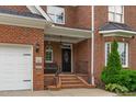 Inviting brick front porch with black door and matching black iron railings at 2112 Tulare Ct, Raleigh, NC 27612
