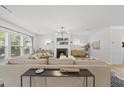 Bright living room features a fireplace, large windows, and modern lighting fixtures at 2634 Turner Pines Dr, New Hill, NC 27562