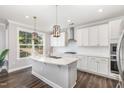 Beautiful white kitchen with a large island, stainless steel appliances, pendant lights, and ample counter space at 2885 Farmhouse Dr, Apex, NC 27502