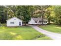 Exterior showcasing a well-manicured lawn, a detached garage, and a long driveway to the house at 300 Plantation Rd, Clayton, NC 27520
