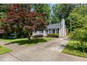 Well-kept gray home featuring a large front yard and mature landscaping at 305 Burkwood Ln, Raleigh, NC 27609