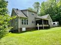 Rear exterior view of home with screened-in porch and lush green lawn at 327 Beavertail Rd, Henderson, NC 27537