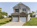 Two-story home with vinyl siding, brick base, and two-car garage with a view of the backyard at 3507 Portico Ln, Durham, NC 27703