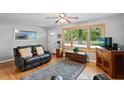 Inviting living room featuring large windows, a ceiling fan and a leather sofa at 3515 Luna Ln, Durham, NC 27705