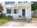 Close-up of front porch with white railings, a green door, and well-kept landscaping at 3634 Ranbir Dr, Durham, NC 27713