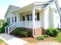 Charming home featuring a lovely covered front porch with white railings and brick accents at 3803 Ridgewood Dr, Franklinton, NC 27525