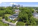 Aerial view of new construction home featuring modern design, landscaping, and city skyline in the background at 409 E Lee St, Raleigh, NC 27601