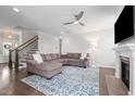 Comfortable living room featuring a fireplace, ceiling fan, plush seating, and staircase at 4420 Bonnie Loch Dr, Burlington, NC 27215