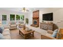 Cozy living room featuring a brick fireplace, comfortable seating, and bright natural light at 5 Wembley Ct, Durham, NC 27705