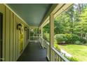 Inviting covered front porch with dark floors, white railings, and an inviting view of the surrounding greenery at 520 Brittany Bay W, Raleigh, NC 27614