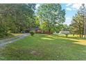 Quaint home featuring a large front yard with mature trees and driveway offering ample parking space at 586 New Hope Church Rd, Apex, NC 27523