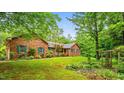 Brick home featuring a meticulously maintained lawn and an inviting, landscaped front yard at 5939 Florasaline Dr, Mebane, NC 27302