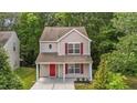 Charming two-story home with red door and shutters and landscaped front yard at 6604 Frogstool Ln, Raleigh, NC 27610