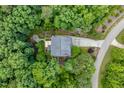 Aerial view of a private wooded lot showcasing a house with a backyard seating area, offering serene outdoor living at 776 Legend Oaks Dr, Chapel Hill, NC 27517