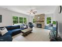 Bright living room boasts a stone fireplace, large windows, plush seating, and neutral carpeting at 776 Legend Oaks Dr, Chapel Hill, NC 27517
