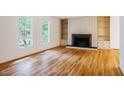 Bright living room featuring hardwood floors, a fireplace with built-ins, and large windows offering natural light at 803 Churchill Dr, Chapel Hill, NC 27517