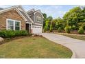 Well-manicured front lawn, a long driveway leading to the two-car garage, and mature trees offering curb appeal at 829 Churton Pl, Cary, NC 27518
