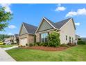 Charming house featuring a two-car garage, brick and siding accents, complemented by lush greenery and manicured lawns at 839 Old Towne Dr, Elon, NC 27244