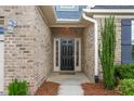 Elegant front door framed by brick, sidelights, and manicured landscaping, creating a welcoming entrance at 839 Old Towne Dr, Elon, NC 27244