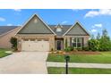 Inviting single-Gathering home with brick, siding, a two-car garage, manicured lawn, and a charming front entrance at 839 Old Towne Dr, Elon, NC 27244