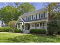 A beautiful two-story home with a front porch, dark green shutters, complemented by lush green lawns and landscaping at 8608 Cheerful Ct, Raleigh, NC 27615