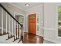Bright foyer featuring hardwood floors, a staircase with black accents, and natural light at 1005 Barmkin Pl, Knightdale, NC 27545