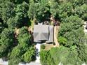 A sprawling home is nestled among dense trees, featuring a well-maintained roof and outdoor seating area at 1009 Blue Larkspur Ave, Wake Forest, NC 27587
