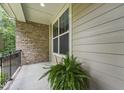 Cozy porch with brick and neutral siding, potted plants, and great light for relaxing at 1009 Blue Larkspur Ave, Wake Forest, NC 27587