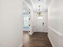 Bright entryway featuring wood floors, white trim, and an elegant chandelier at 1030 Steinbeck Dr, Durham, NC 27703