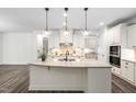 Spacious kitchen with white cabinetry, a granite island, and modern light fixtures at 1030 Steinbeck Dr, Durham, NC 27703