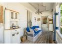 Cozy porch offers ample seating with wicker furniture and a cabinet at 110 E Church St, Creedmoor, NC 27522