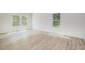 Bright bedroom featuring wood-look flooring, neutral walls, and large windows offering ample natural light at 110 Hays St, Oxford, NC 27565