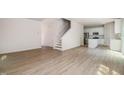 Spacious open-concept living area featuring wood-look floors, staircase, kitchen, and lots of light at 110 Hays St, Oxford, NC 27565