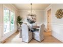 Elegant dining room with hardwood floors, wainscoting, and a stylish chandelier at 1206 Chalk Maple Dr, Cary, NC 27519