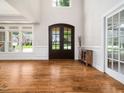 Bright foyer featuring hardwood floors, white walls, and a large window and double glass doors at 12424 Beauvoir St, Raleigh, NC 27614