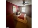 Bedroom showcasing a comfortable bed, classic ceiling fan, and natural light from the windows at 130 Beechwood Dr, Carrboro, NC 27510