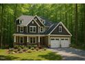 Beautiful two-story home with dormer windows, a two-car garage, and surrounded by lush greenery at 1412 Auman Rd, Raleigh, NC 27603