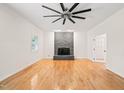Bright living room with hardwood floors, stone fireplace, and a modern ceiling fan, creating a welcoming space at 1514 Lawrence Rd, Creedmoor, NC 27522