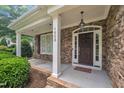 Charming front porch featuring stone accents, white columns, and a stylish front door at 1608 Heritage Links Dr, Wake Forest, NC 27587