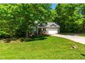 Beautifully landscaped front yard with lush greenery and a charming home nestled in trees at 166 Daffodil Ln, Clayton, NC 27527