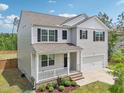 Charming two-story home with gray siding, a covered porch, and a two-car garage at 170 Baker Farm Dr, Youngsville, NC 27596